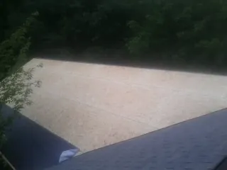New OSB roof sheathing installed beside an existing shingle roof in Washington